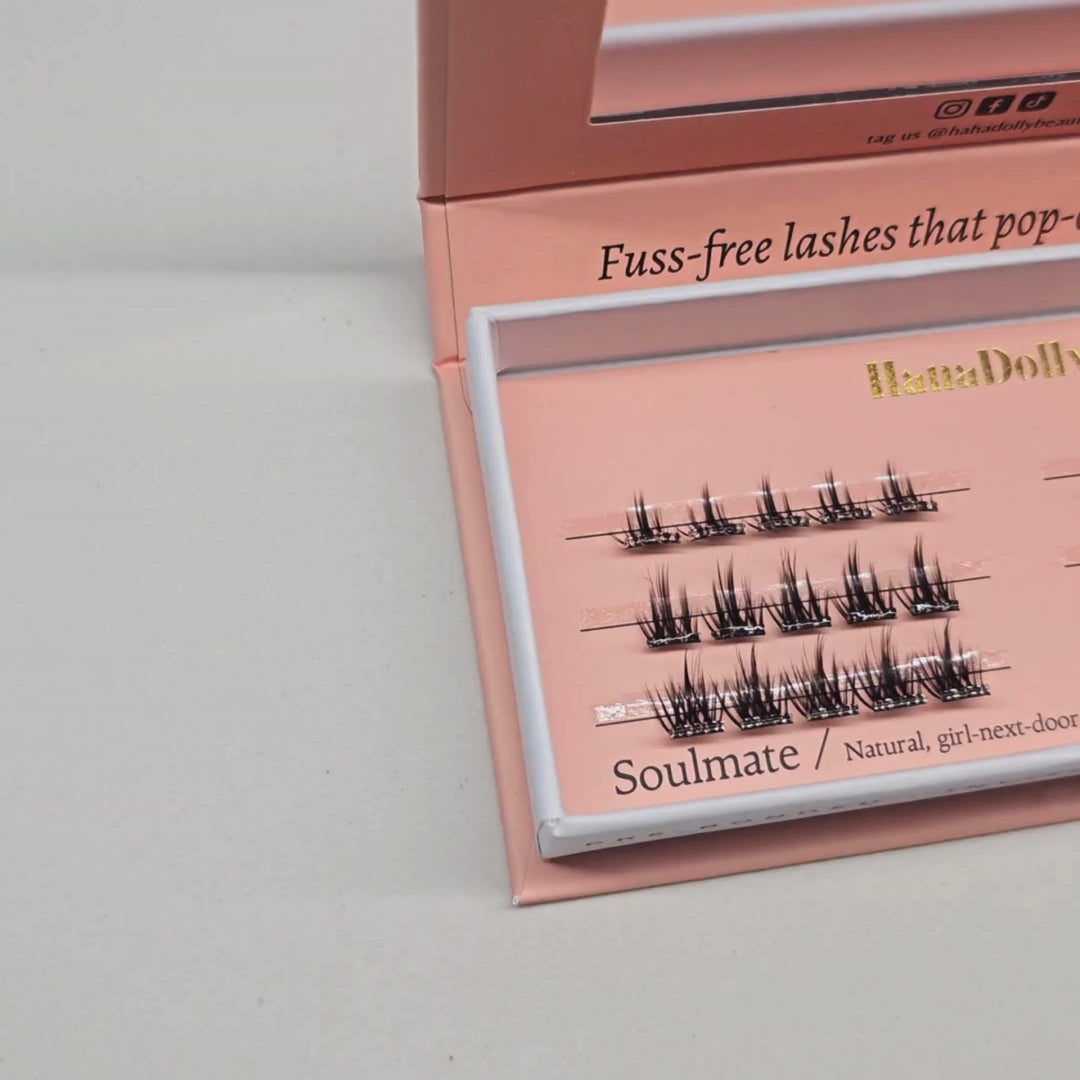 Close up video of HanaDolly's Soulmate press-on lashes in their pink box packaging with the top opened and zoomed in on the rows of pre-glued lashes inside.