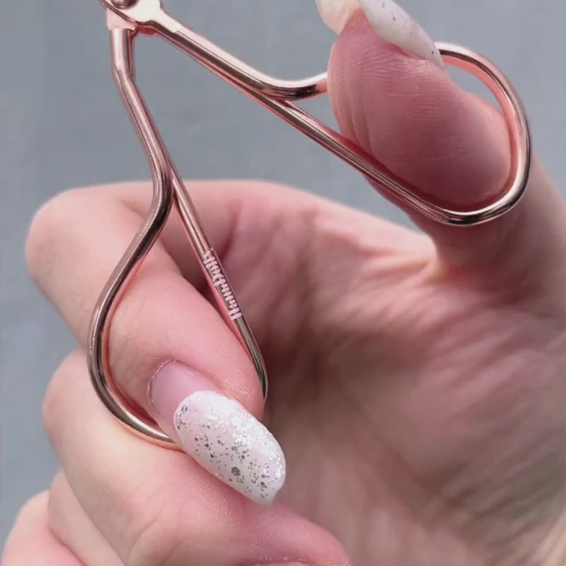 Showcase of the press eyelash curler in use as well as its packaging box