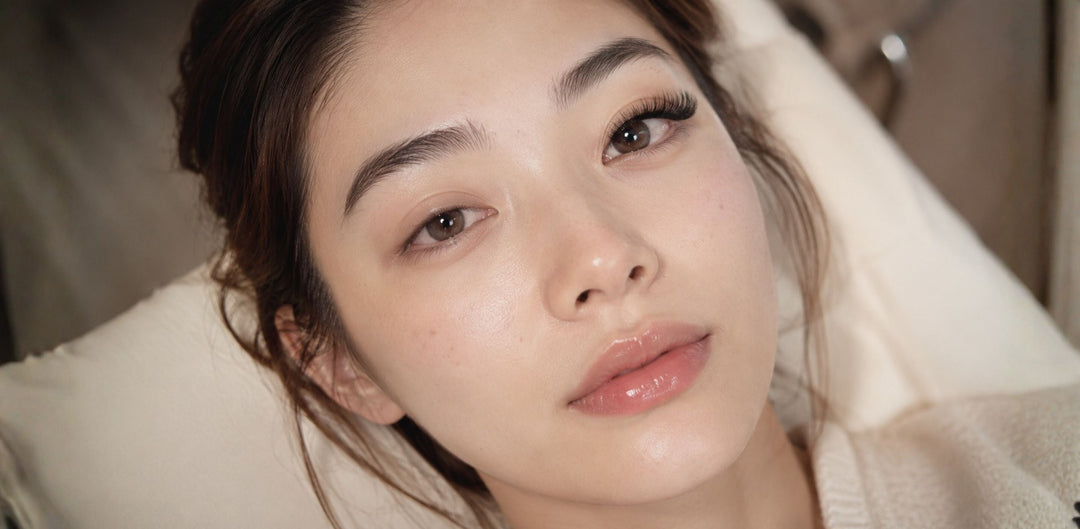 Asian woman showing one eye with eyelash extensions and one eye with shorter natural lashes for a Singapore blog comparing salon eyelash extension cost with DIY press-on lashes.