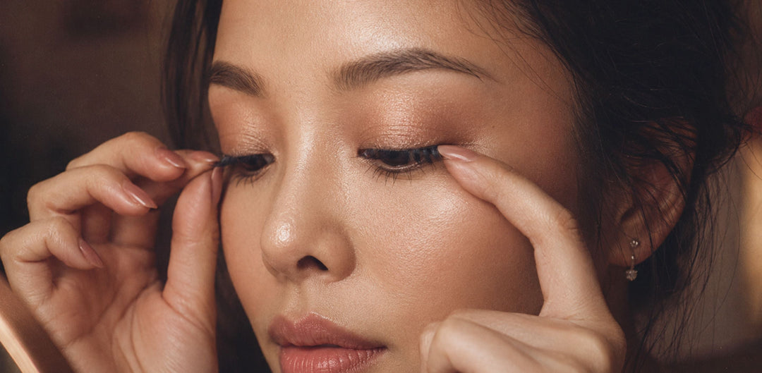 Asian woman applying wispy press-on lash clusters, showing the best false eyelashes for beginners who want a soft natural lash look.