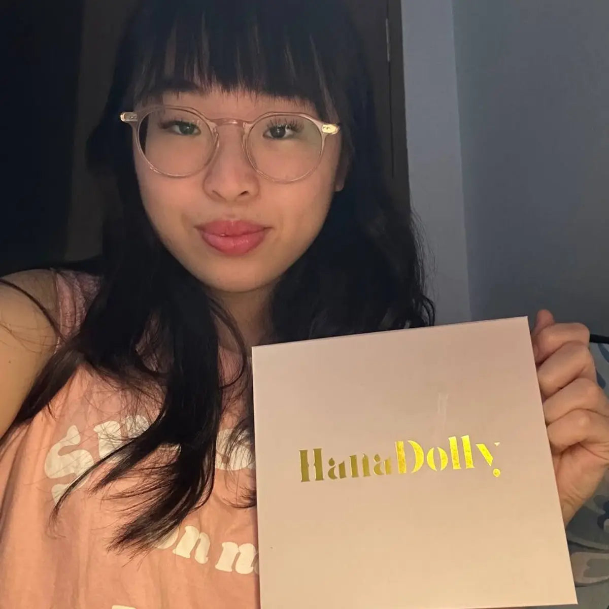 Woman holding HanaDolly DIY lash kit after applying press-on lashes