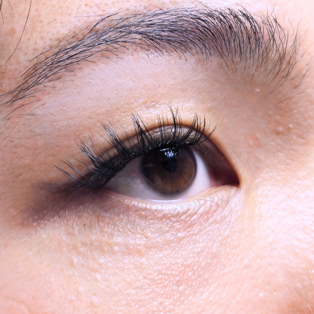 Close-up of a model's eye wearing Adore press-on lashes (self-adhesive lashes) by HanaDolly NIMBLE collection.