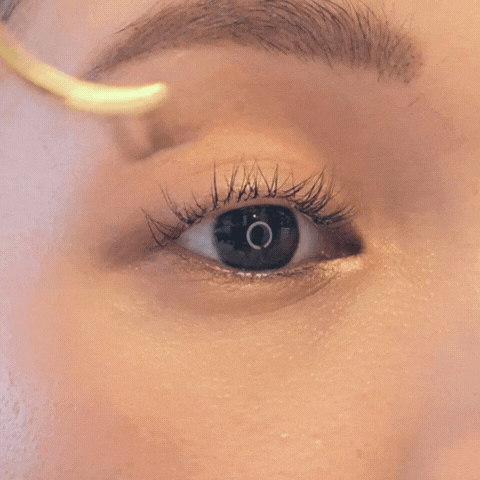 Placing DIY lash extension cluster under natural lashes for a natural look