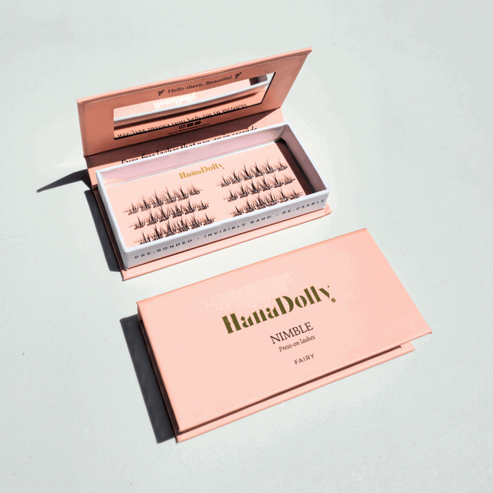 Flat lay iamge of HanaDolly's Fairy press-on lashes in an open pink HanaDolly box, showcasing reusable lashes with pre-bonded adhesive.