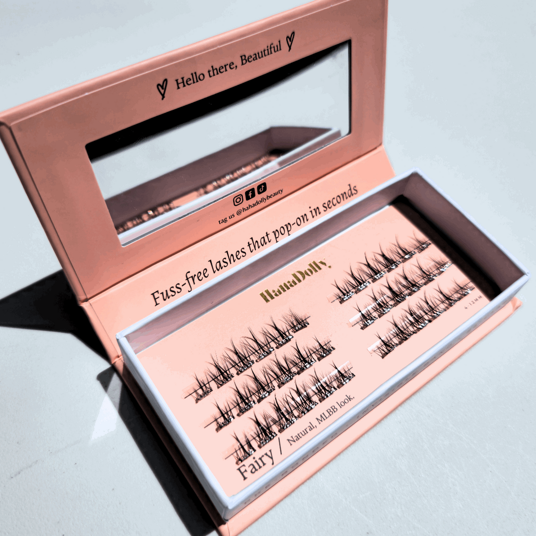 Angled flatlay of Fairy press-on lashes in an open pink box, showing individual lash clusters for easy application.