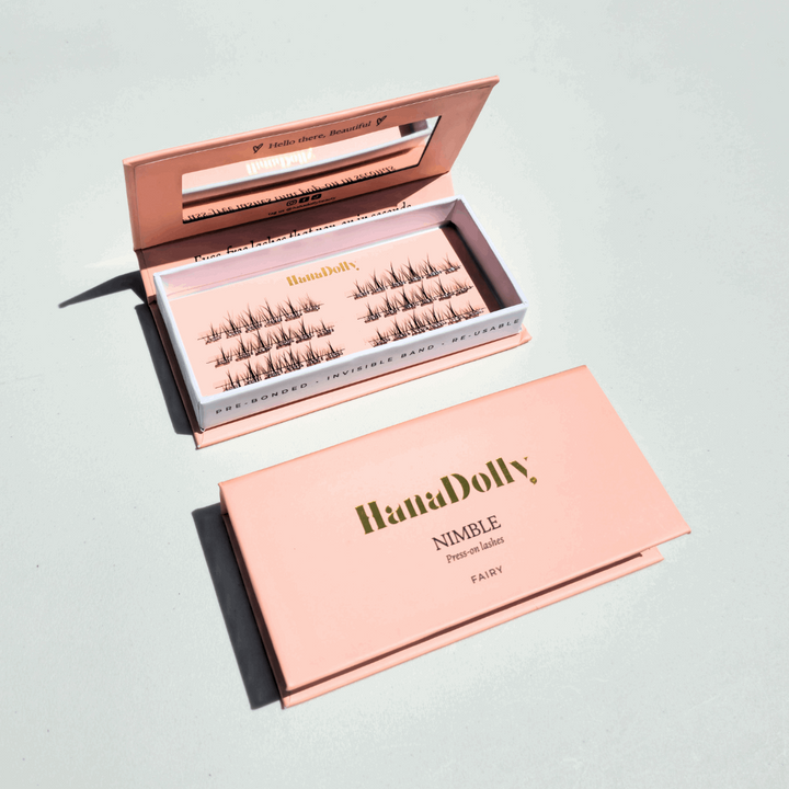 Flatlay of HanaDolly's Fairy press-on lashes in an open pink HanaDolly box, showcasing reusable lashes with pre-bonded adhesive.