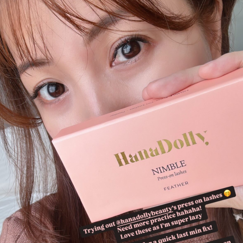 Woman holding HanaDolly Nimble press-on lash box near her eyes